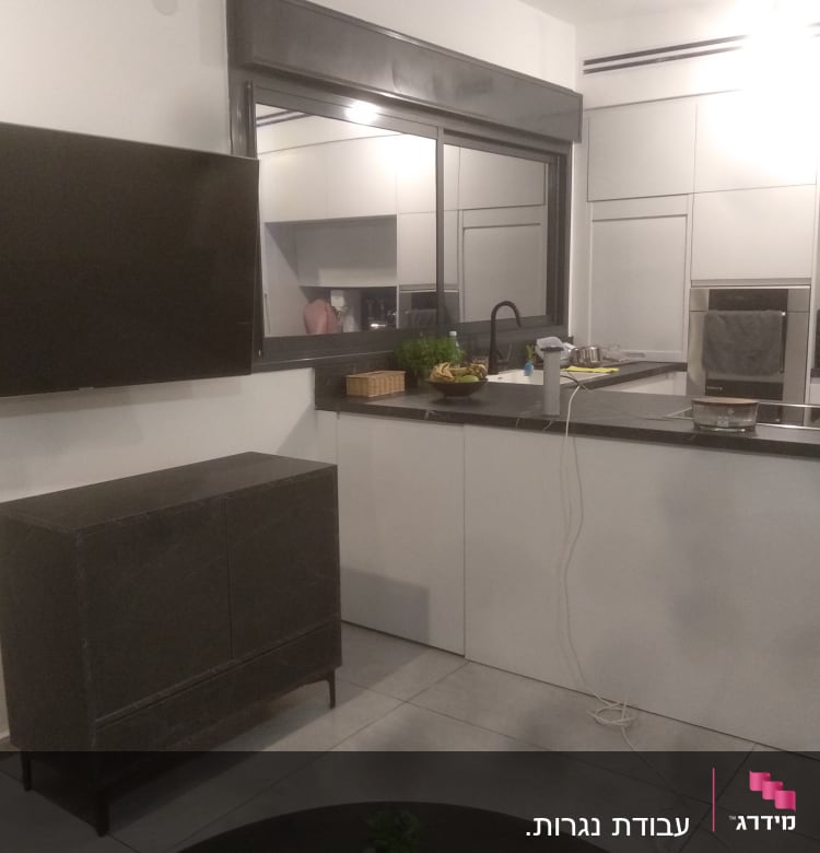 מטבח מודרני עם ארונות לבנים ומשטח עבודה שחור